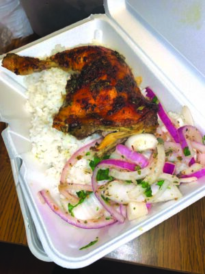 Jerk chicken plate with white rice and marinated onions.