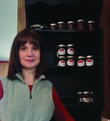 woman standing in front of shelf of jams and jellies