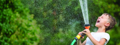 kid playing with water hose