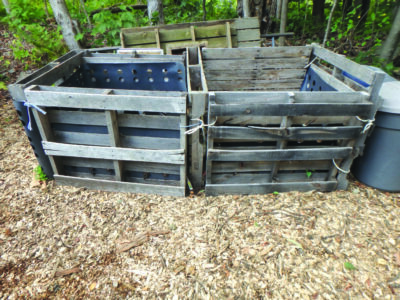 wooden pallets tied together to form compost bins