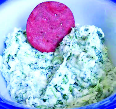 close up of cracker in spinach dip