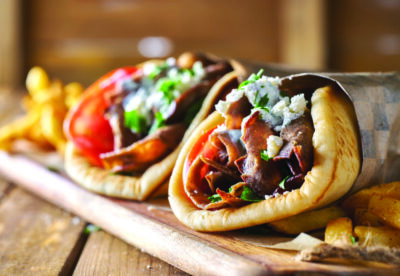 gyros wrapped in paper on wooden board
