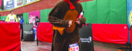 runner wearing turkey costume crossing the finish line of race on rainy day