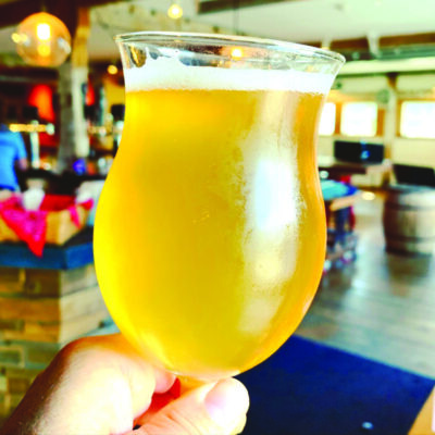 hand holding glass of light beer in restaurant
