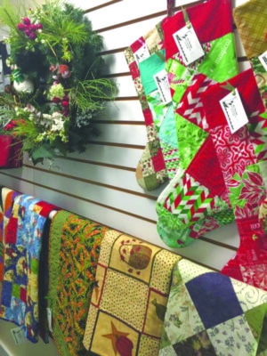 Christmas themed textile crafts hanging on display wall
