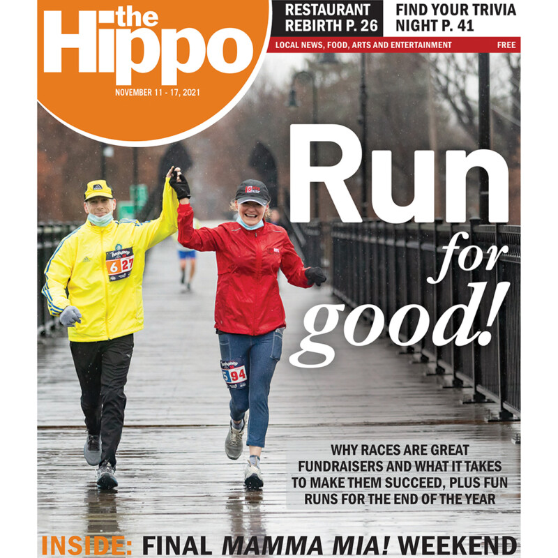 magazine cover showing two people running across bridge in rain