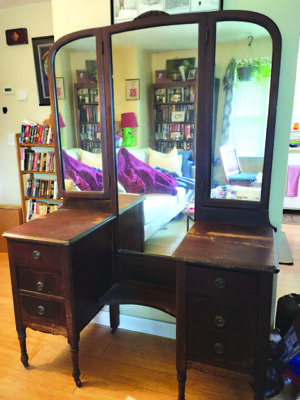 antique wooden vanity with three tall mirrors and drawers on each side