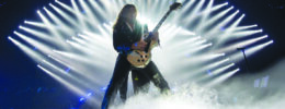 electric guitarist on performing on stage with smoke and white lights