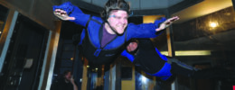 2 men hovering in air in sky diving simulation room