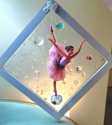 diamond shaped glass window in frame, decorated with ballerina and colorful circles