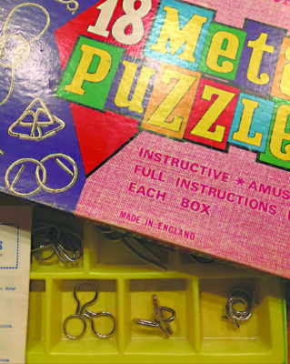 open box of metal puzzle toys from the 1960s