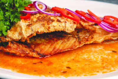 fish dinner in sauce, covered with onions and peppers