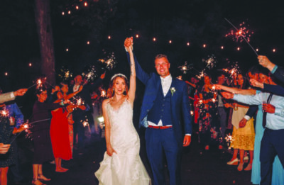wedding couple at night, guests lined up with sparklers on both sides