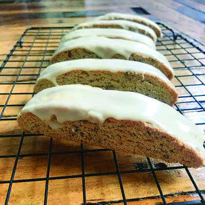 biscotti with icing on top, laid in row on cooling rack