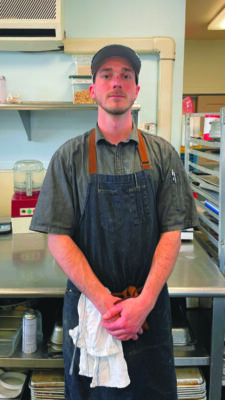 young man wearing apron in commercial kitchen