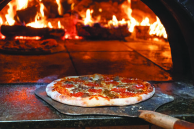 pizza being pulled from wood fired oven