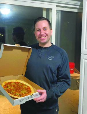 Man holding open pizza box