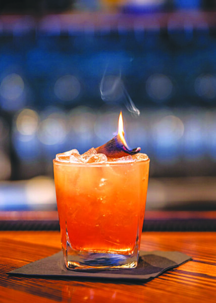 cocktail in glass with ice, set on fire