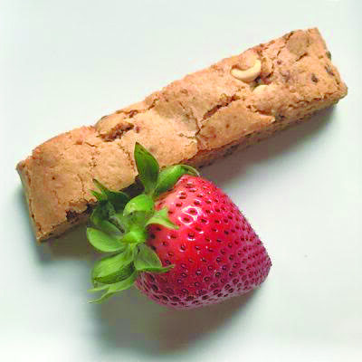 piece of biscotti set next to ripe strawberry