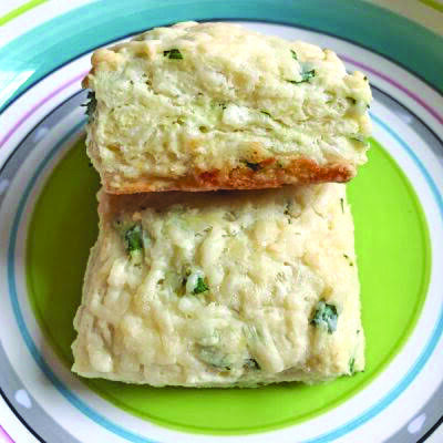 2 cheddar and chive square scones sitting on plate