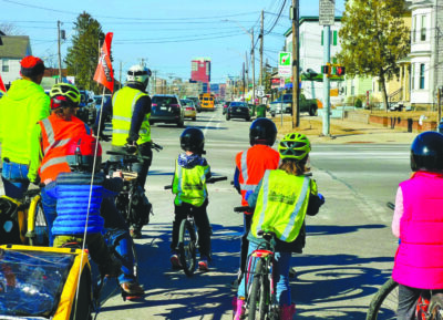 kids riding bikes to school on city street