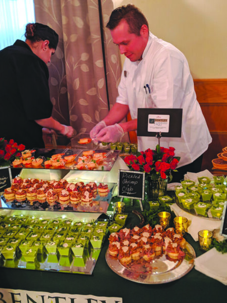 2 chefs preparing h'ours d'oeuvres at event table