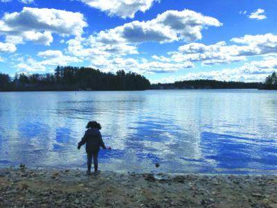 Child standing at lake shore
