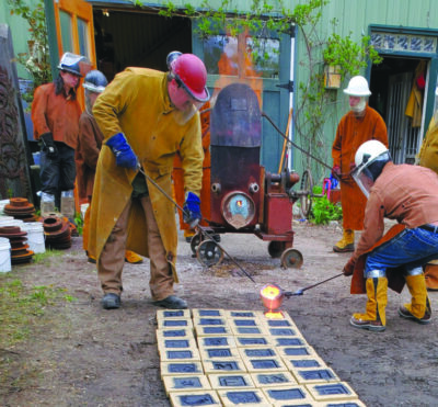 pouring hot iron into tiles laid out on ground