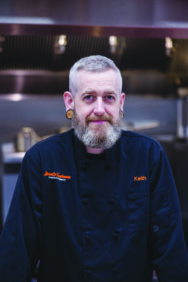 gray haired man in chef's uniform, in restaurant