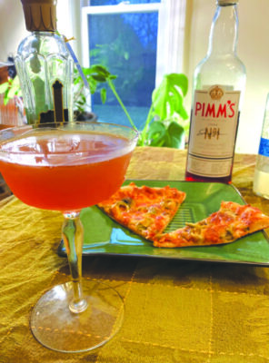 cocktail beside plate of pizza