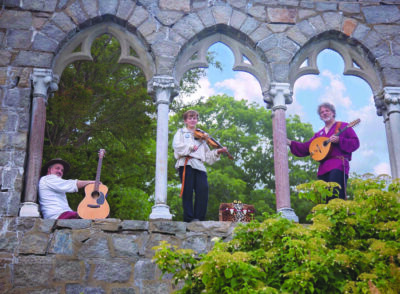 3 string musicians standing in arched stone windows, dressed in historic costume