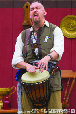 man in costume at renaissance faire, playing hand drum