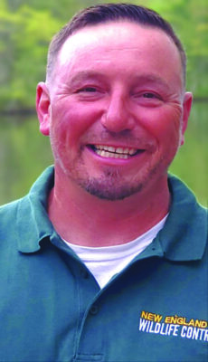 smiling man, outside, wearing New England Wildlife Control shirt