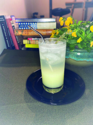 cocktail with goat cheese on counter with flowers and books