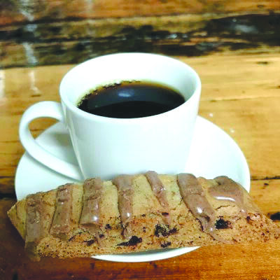 Spiced date biscotti on plate with cup of coffee