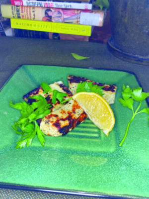 charcoal grilled haloumi on plate with lemon and parsley