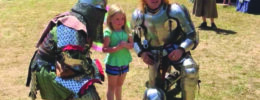 Actors in armor posing with small girl