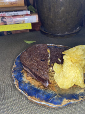 grilled cheese on pumpernickel on plate with chips