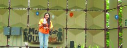 teenage girl with megaphone, giving speech on platform in park