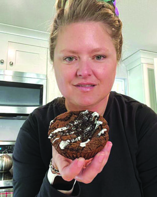 woman in kitchen holding baked good