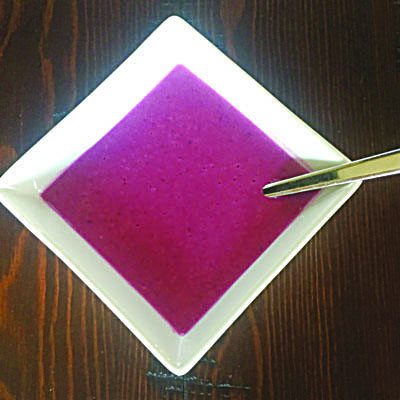 square bowl filled with purple soup, spoon