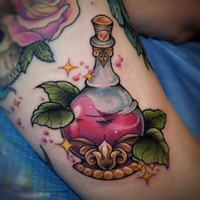 tattoo of glass fantasy bottle with decorated bottom, surrounded by leaves and stars, half full
