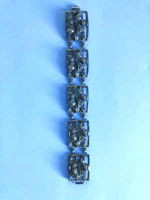 sterling silver bracelet laid out on blue surface