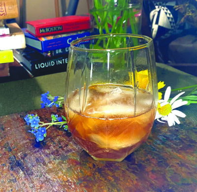 cocktail in a glass beside picked flowers