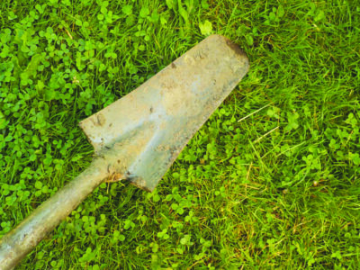 a well used drain spade lying on grass