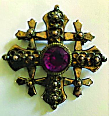 broach in the shape of a square cross with smaller crosses in the corners, round stone of colored glass set in the middle