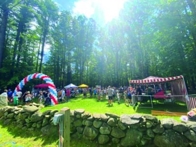 event tents and balloons set up beyond stone wall during daytime event