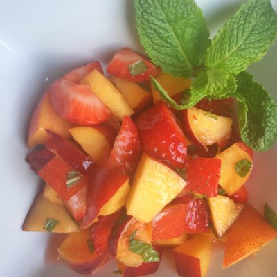 plate of cut up nectarines and strawberries with mint leaf garnish