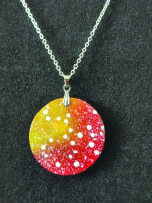 a pendant necklace painted with dots