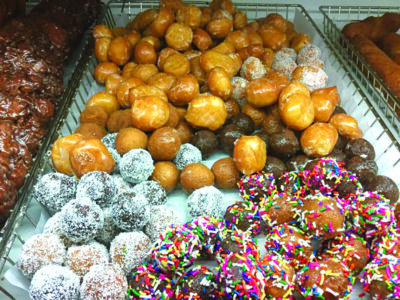 fresh small round doughnuts with various toppings piled in bakery basket